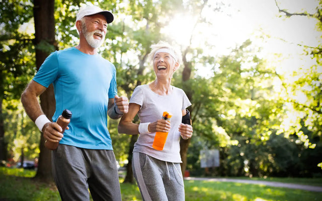 Glada seniorer som joggar i naturen